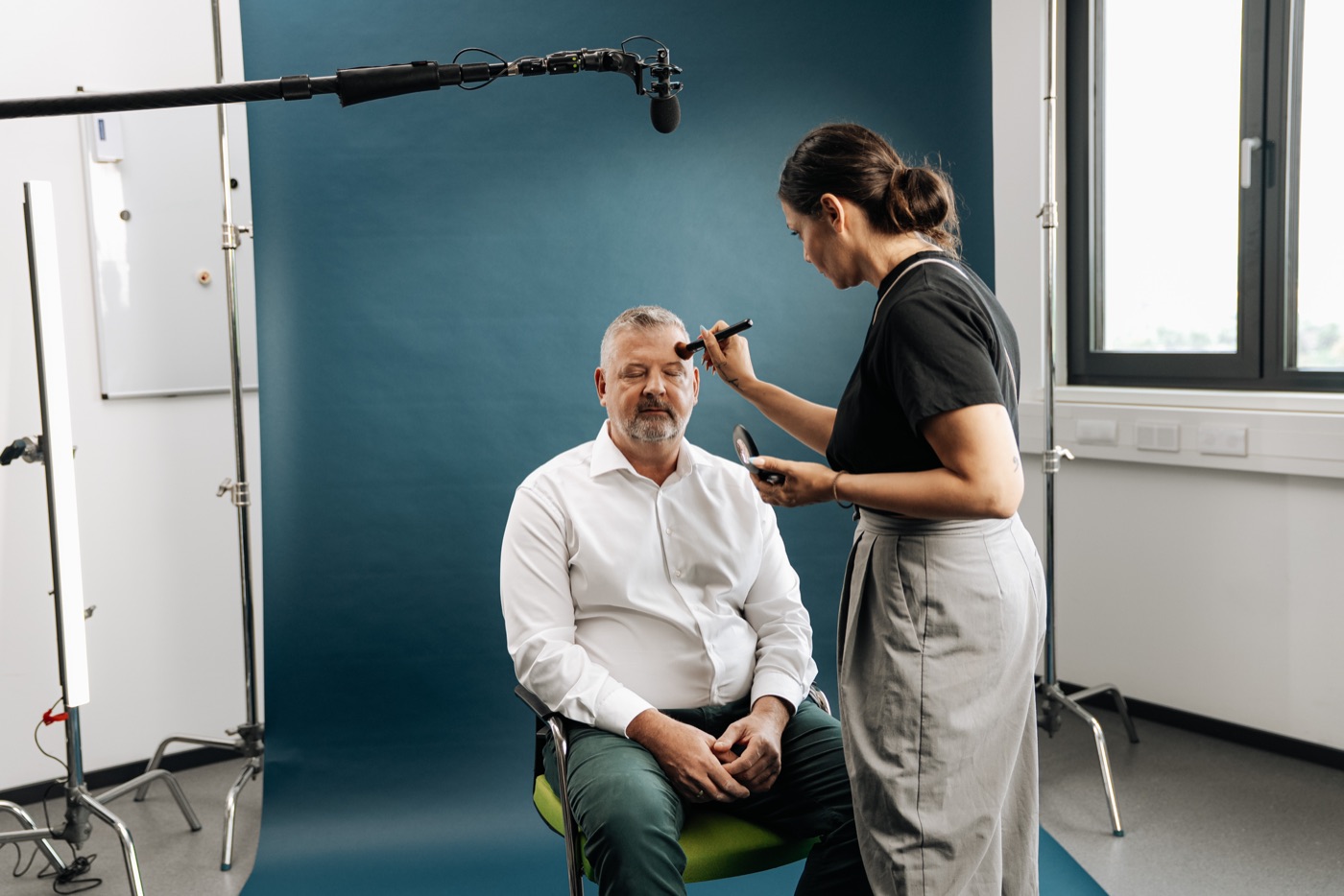 Letzte Maske vor dem Take: Interviewgast unter der Tonangel mit Windschutz.
